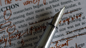 Image of old style pen on red marked paper.