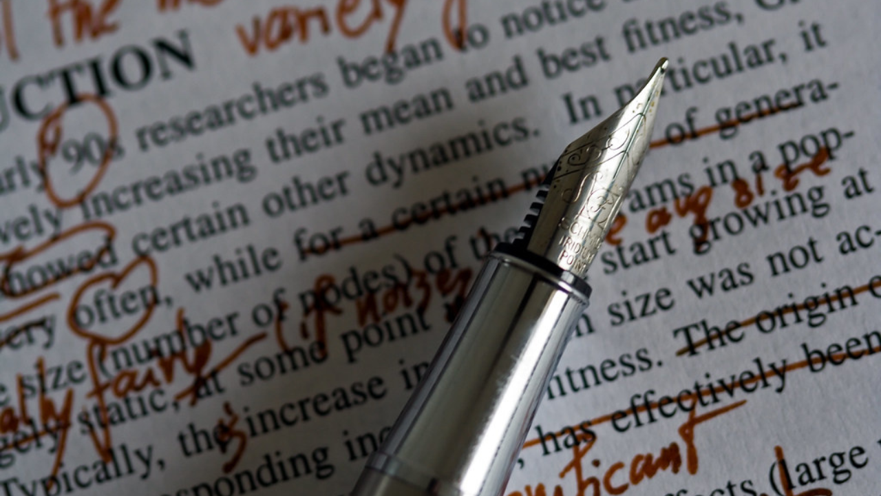 Image of old style pen on red marked paper.